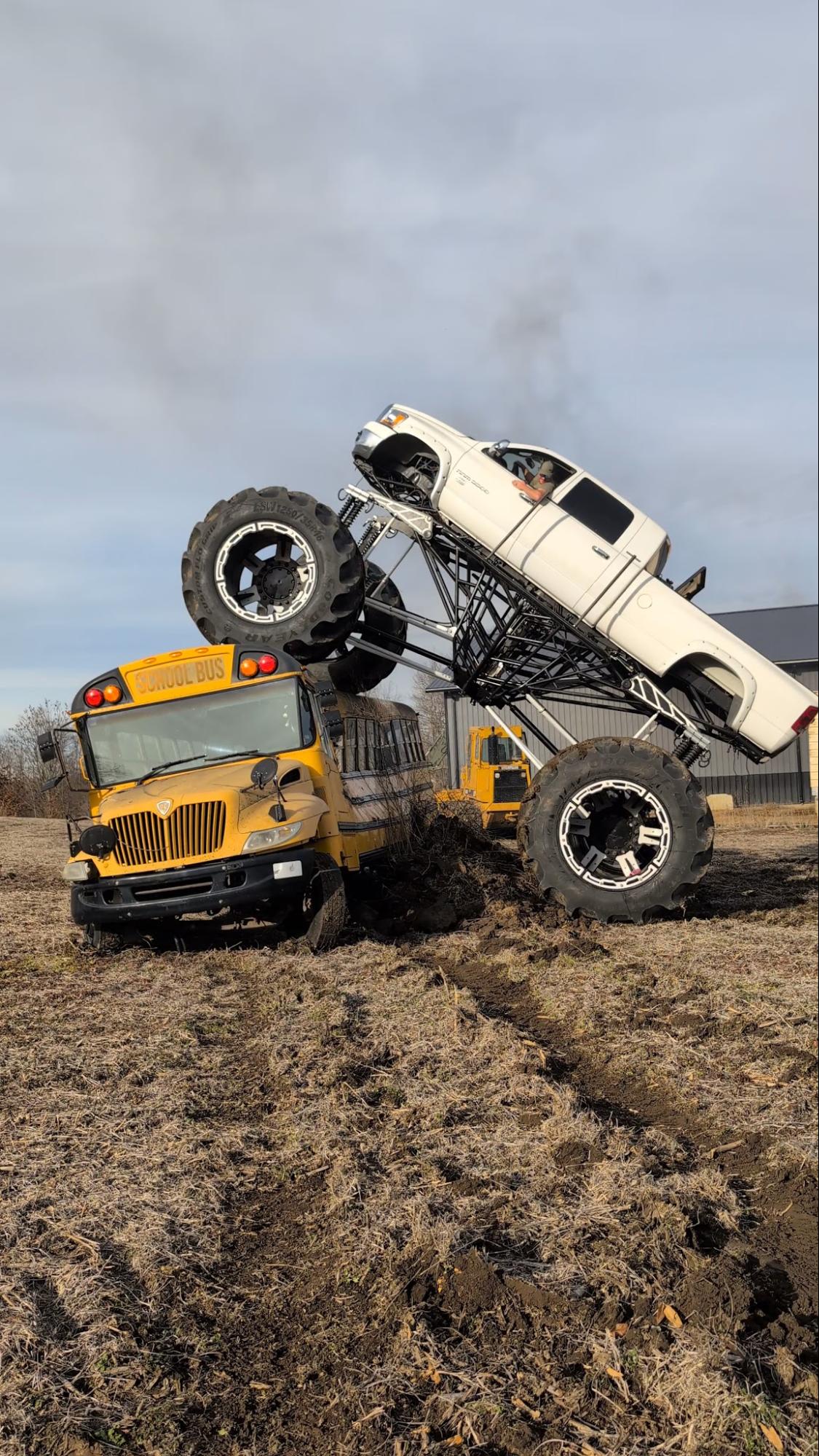 MO Man Offroad monster truck climbing over a school bus